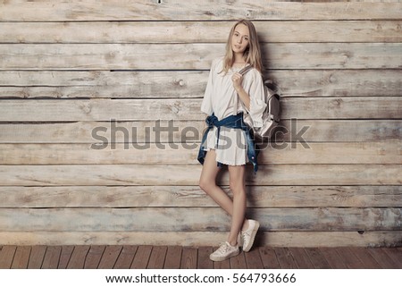 Fashion lifestyle portrait of young pretty woman in wooden room