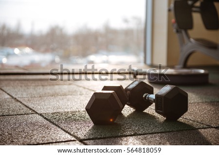 Picture of sport equipment in gym. Dumbbells on floor.