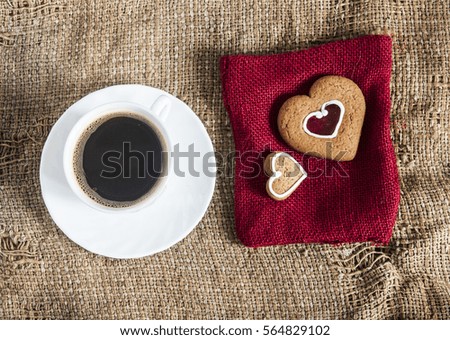 Cup of coffee and cookies valentines on background