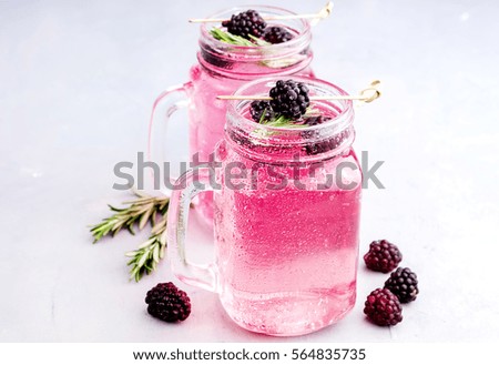 Cold fresh lemonade with blackberry and Rosemary in glass jars 