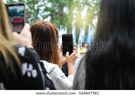 hand holding a smart phone in hand against natural background. Blank screen with copy space