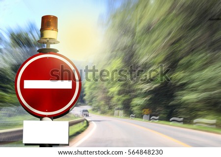 No Entry Sign with orange flashing light. Led.against a blurred traffic on road