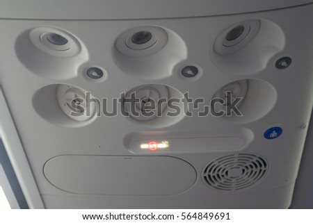 airplane cabin with the fasten belts and no smoking signs 
