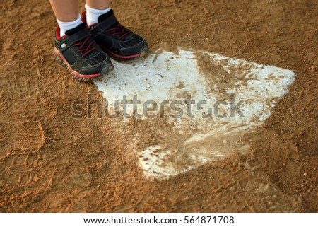 bases loaded, a young child's feet on home plate