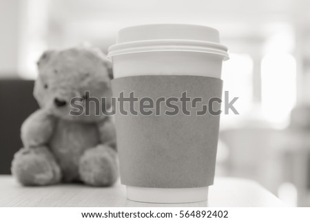 Coffee cup, blurred on teddy bear face in Blurred background with vintage or retro filter, B&W