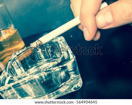 Cigarette in hand and ashtray on a dark background smoking wallpaper