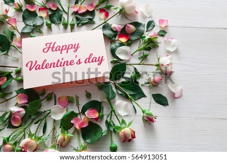 Valentine background with pink rose flowers circle and handmade paper card with copy space on white rustic wood. Happy lovers day mockup