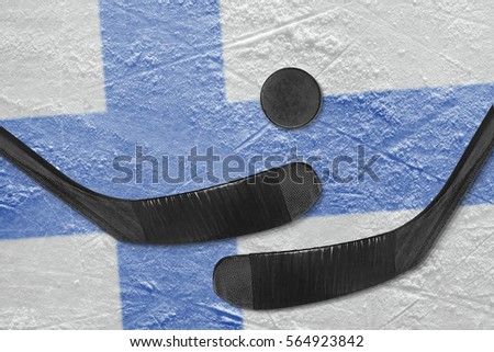 Hockey puck, hockey sticks and a picture of the Finnish flag on the ice. Concept