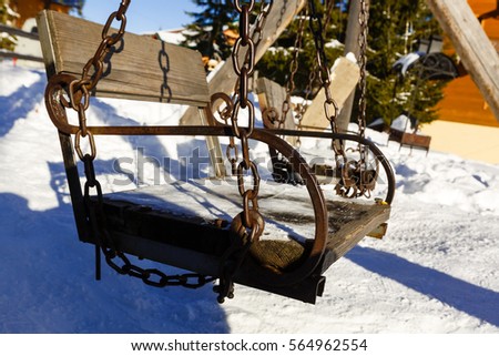 Abstract winter scene with a garden swing covered  snow, appearing to invite everyone  take  break, have  snack and enjoy the landscape  generally the unique moments of the life.