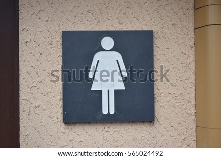 Black female toilet sign on a wall 