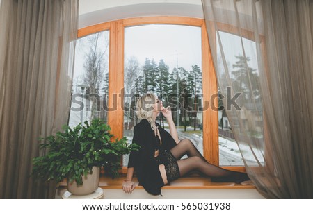 A young girl sitting at a window seat, Winter time.
