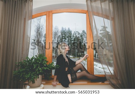 Awesome girl sitting on the windowsill, perfect background, snow. Winter time.