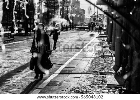 silhouette of walking woman with bags in sunrise time empty street