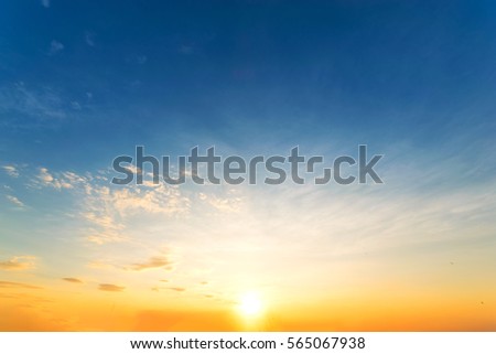 Sky blue and orange light of the sun through the clouds  Royalty-Free Stock Photo #565067938