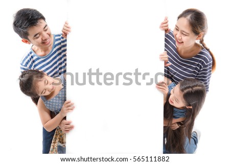 Smiling happy Asian family with big white poster on isolated background Royalty-Free Stock Photo #565111882