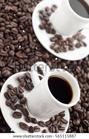 Black coffee and cookies against a backdrop of coffee beans