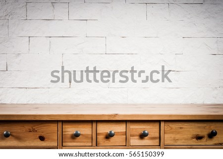 wooden shelf and wall of white bricks