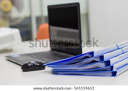 Blue Document folder with documents and Notebook on white table in meeting room 