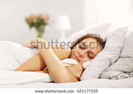 Young woman sleeping in bed Royalty-Free Stock Photo #565177339