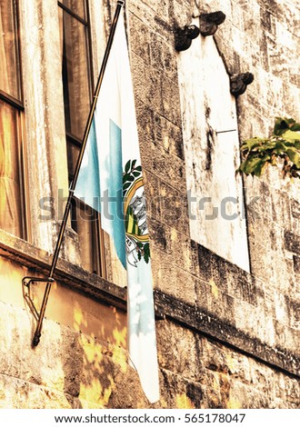 Flag of San Marino out of a medieval building.