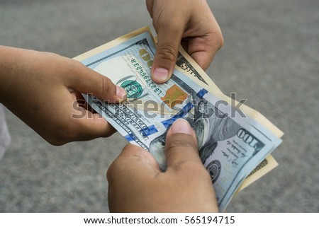 Close up of hand holding and giving USD money