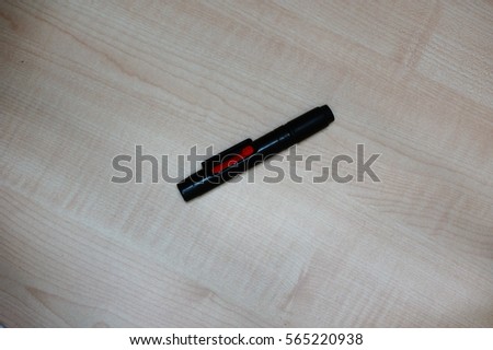 Lens pen brush for cleaning camera on wooden floor