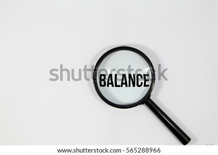 A concept image of a magnifying glass isolated white background with a word BALANCE zoom inside the glass 