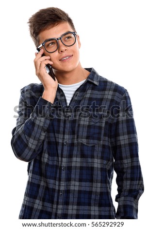 Thoughtful young happy man smiling while talking on mobile phone
