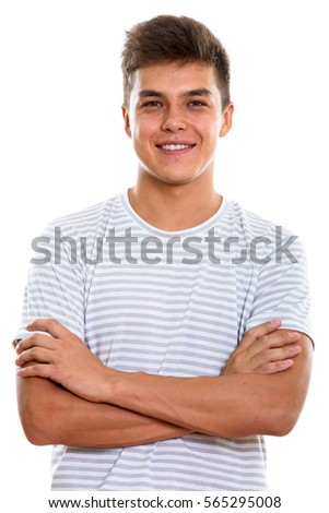 Studio shot of young happy man smiling with arms crossed