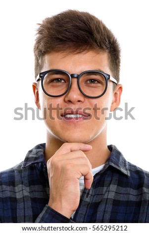 Face of young happy man smiling while thinking