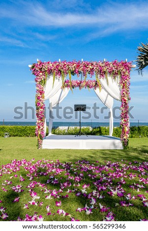 outdoor wedding arch decorated with flowers in the garden nearby the sea