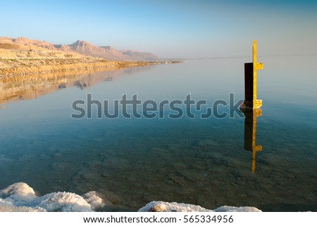 Dead Sea in Israel with rocks of salt at foreground and pillar of water level