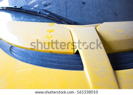 close-up photograph of the body of a yellow sports car from England. The machine in the dust. The picture of the horizontal arrangement. Lotus.