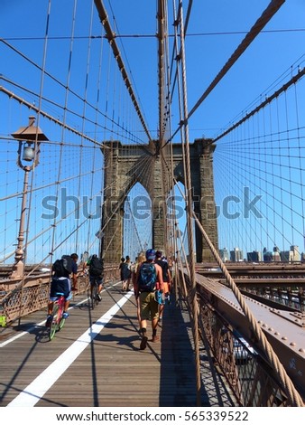 Brooklyn bridge, Manhattan, New York, New York City, USA, America. 15 July 2015. People walking and cycling on the bridge. Crowd going away from the shot. Beautiful lines created by the bridge.