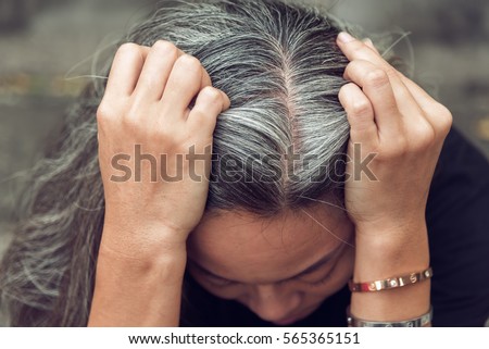 Closeup sad asian young beautiful woman and gray hair with worried stressed face expression looking down Royalty-Free Stock Photo #565365151