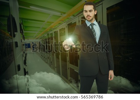 Cheerful businessman pointing at camera against image of data center