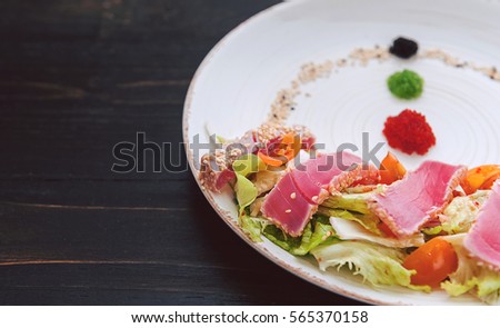 Pan-Asian food. a dish of pan-Asian cuisine on a white plate with dark backgrounds