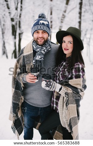 happy young couple  in a forest in winter, outdoor. valentines day, holidays, winter, love story, christmas,  and people concept