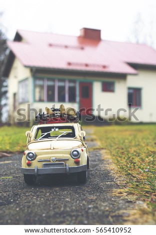 Miniature toy car traveling around the world. Explore the globe. Caricature tin car with perspective shot. A building background out of focus.