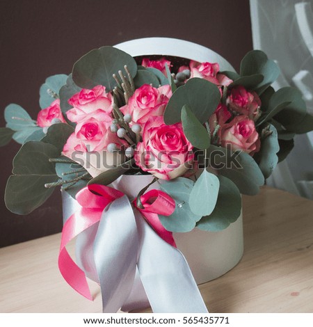 Flower box of pink roses and eucalyptus with big bow. Present on Valentine day