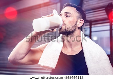 Muscular man drinking protein shake at crossfit gym Royalty-Free Stock Photo #565464112