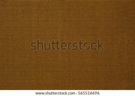 Close up fragment of dense wool fabric wallpaper texture natural pattern textile background in light bright warm color tone of ochre. Creative macro photography of canvas.