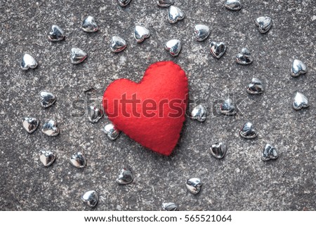 red heart with small siver heart on cement floor,  valentine and love concept