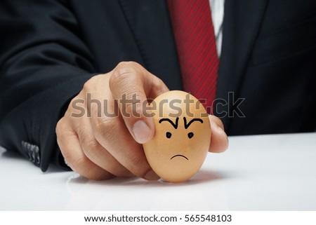 Executive hand holding egg with Mad expression