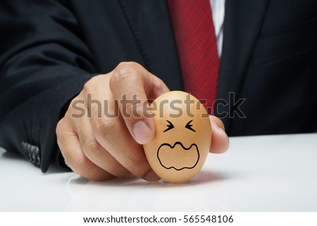 Executive hand holding egg with Stress expression