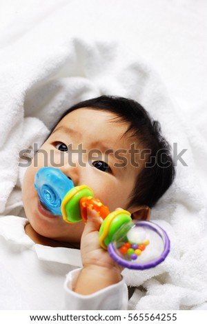 Infant boy biting toy