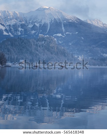 Boats bringing people to Bled island on a cold winter morning
