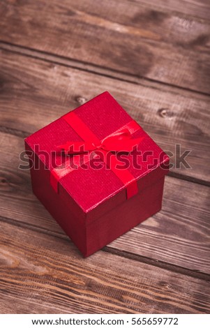 Wrapped red gift box on wooden background can use on valentine day mother day or celebrate love day .