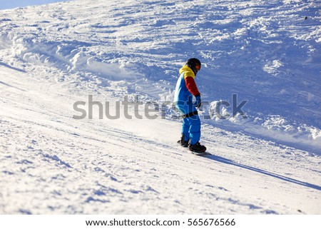 Snowboarder doing a toe side carve with deep blue sky in background snow