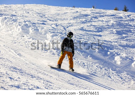 Snowboarder doing a toe side carve with deep blue sky in background snow